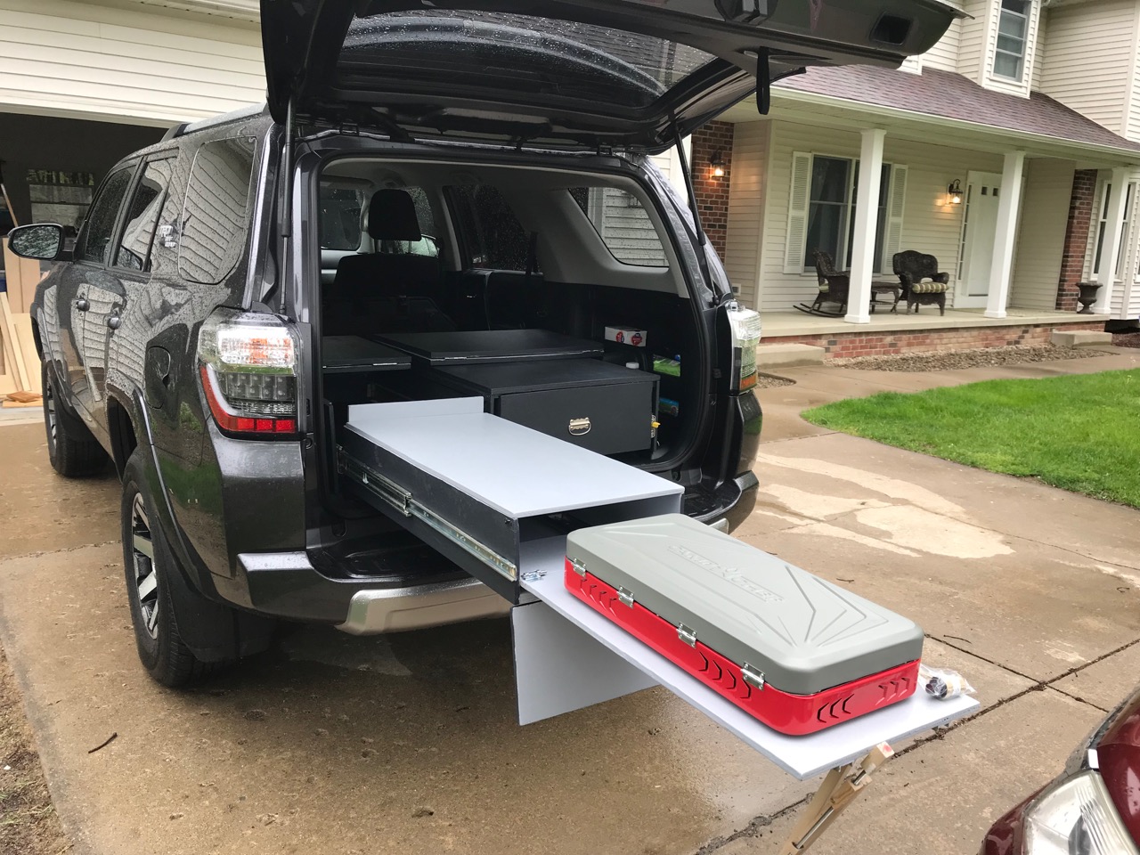 Rear view with left drawer open, removable front panel down, and stove out