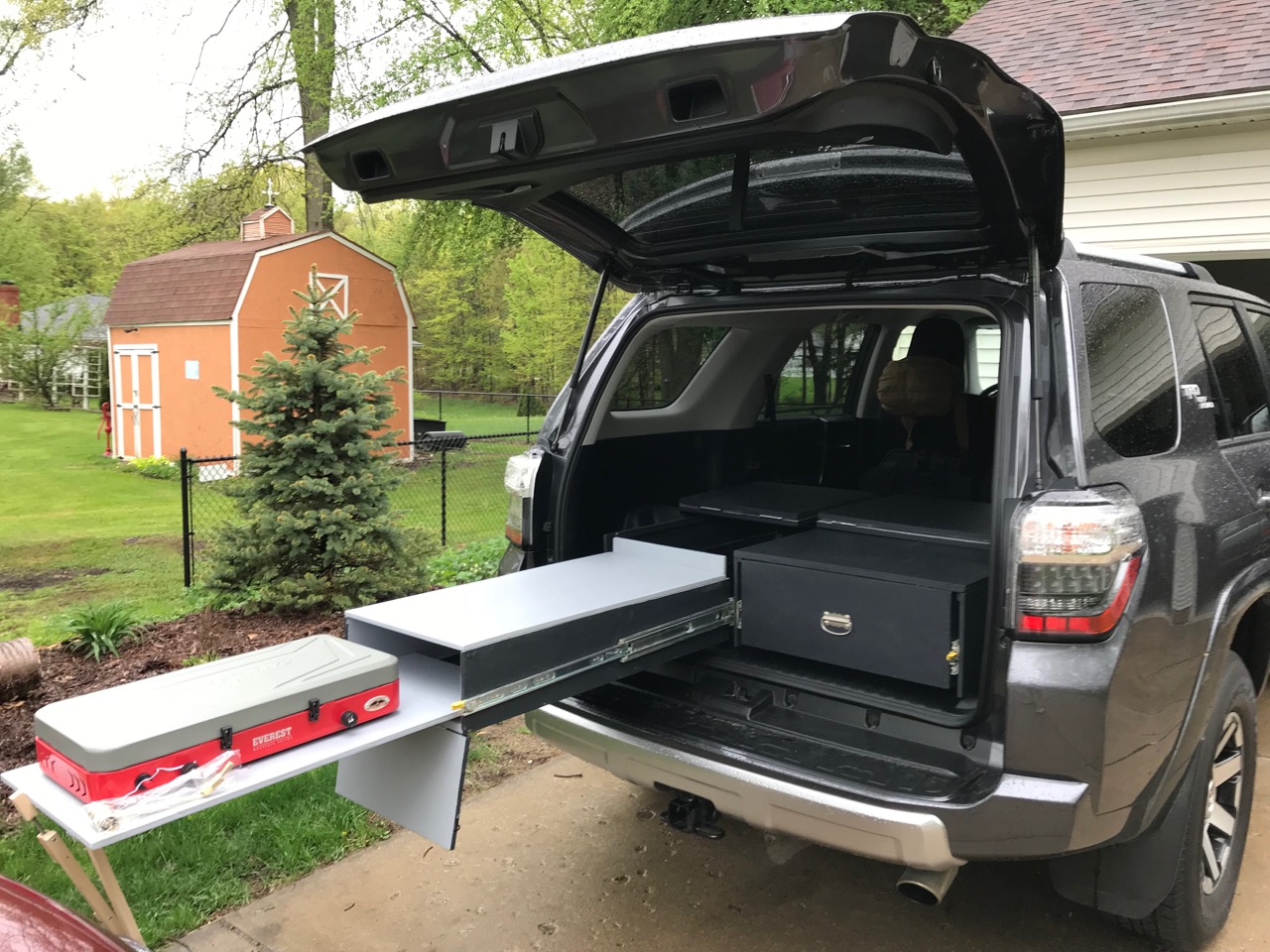 Rear view with left drawer open, removable front panel down, and stove out from front side